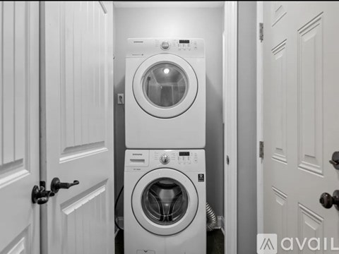A stack of two washing machines in a narrow space.