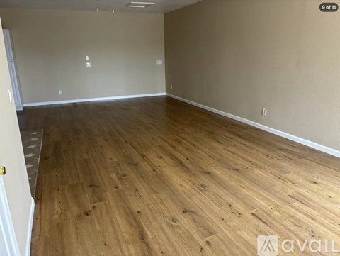 A room with wooden flooring and white walls.