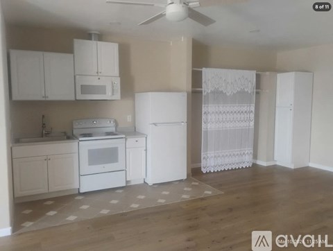 A kitchen with white appliances and cabinets.