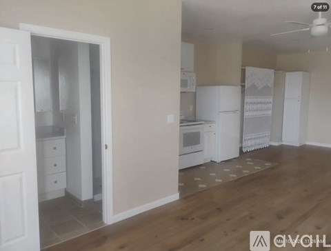 A kitchen with white appliances and cabinets is shown.