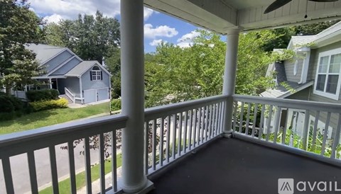 A balcony with a view of a house and trees.