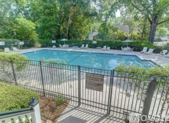 A pool surrounded by a fence and trees.