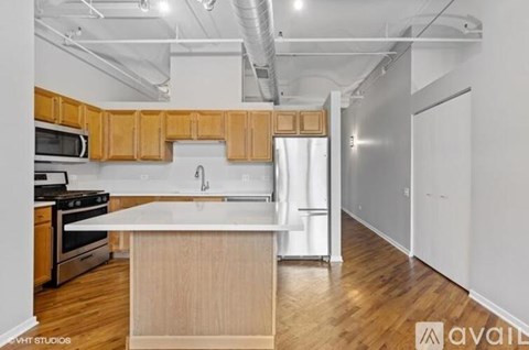 A kitchen with wooden cabinets and a white island.