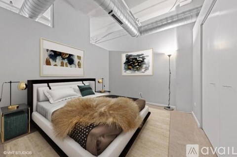 A bedroom with a bed, a lamp, and two pictures on the wall.