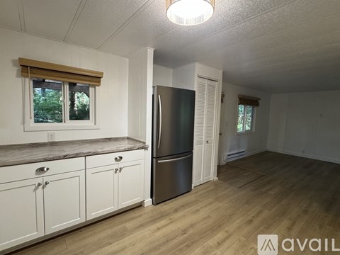 A kitchen with white cabinets and a stainless steel refrigerator.