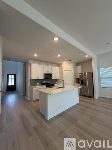 A modern kitchen with white cabinets and a central island.