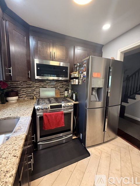 A kitchen with a stove top oven and a refrigerator.