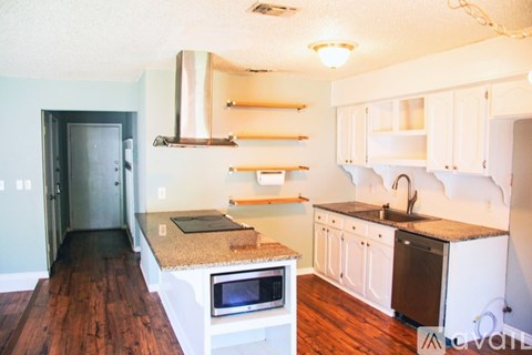 A kitchen with a white oven and a black door.