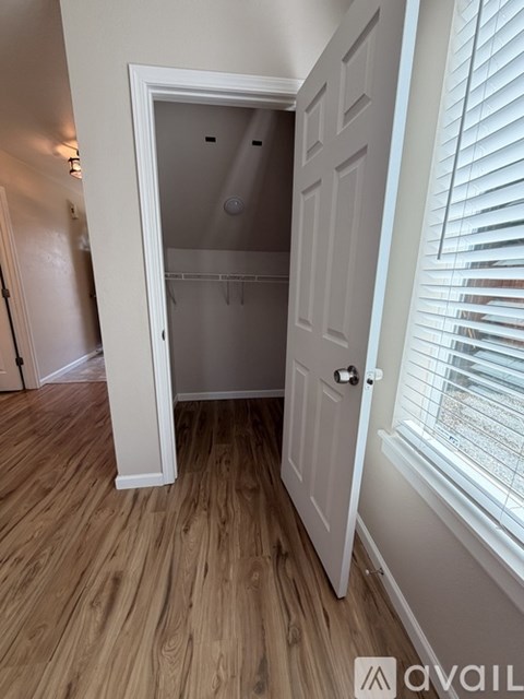 A white door is open to a bathroom with a shower.