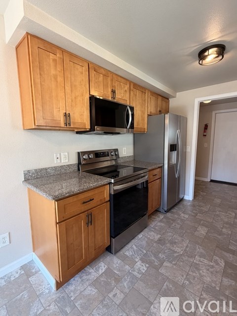 A kitchen with wooden cabinets and a granite countertop.