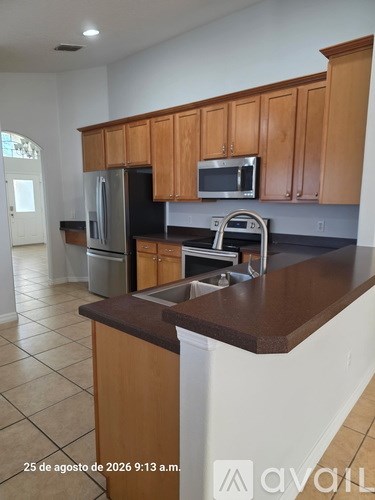 A kitchen with wooden cabinets and a black countertop.