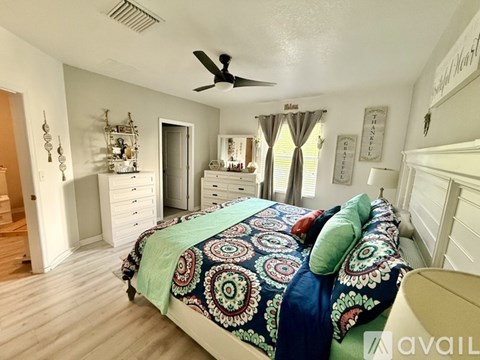 A bedroom with a bed, dresser, and mirror.