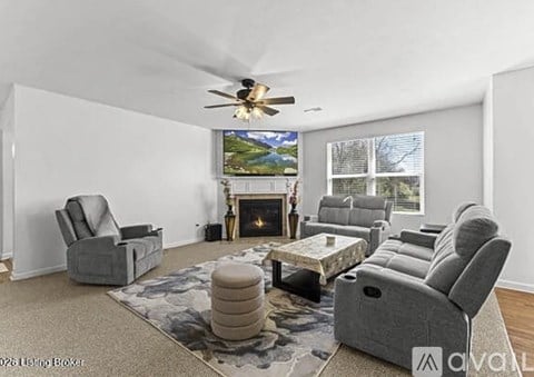 A living room with grey furniture and a fireplace.