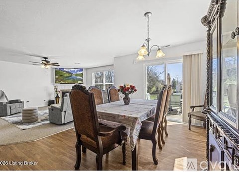 A dining room with a table set for four and a view of the outdoors.