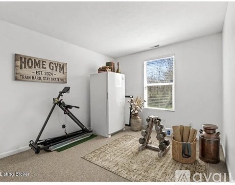 A home gym with a wooden sign on the wall and exercise equipment.