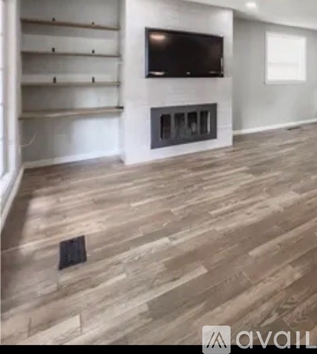 A living room with a fireplace and a television mounted above it.