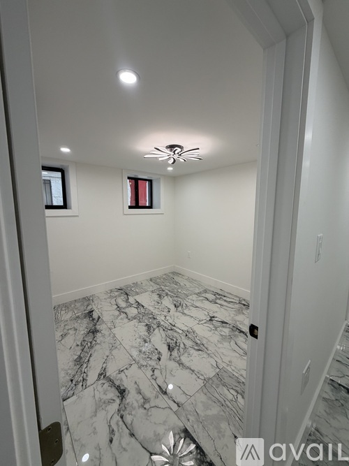 A room with a marble floor and a ceiling fan.