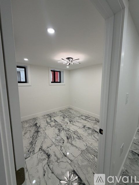 A room with a marble floor and a ceiling fan.