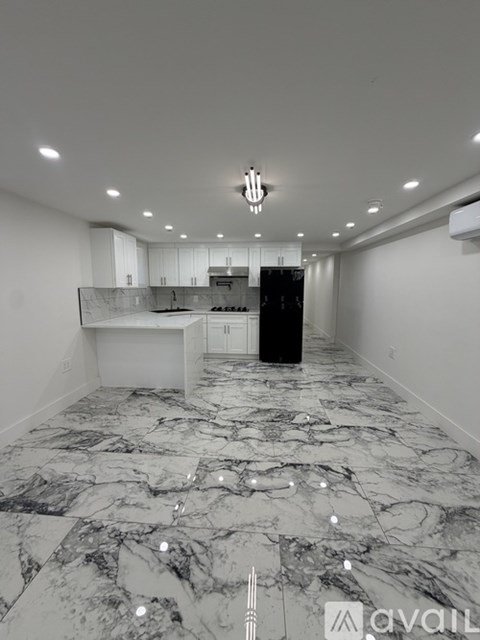 A spacious kitchen with marble flooring and a modern design.