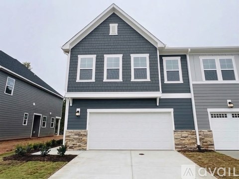 A two-story house with a garage door.