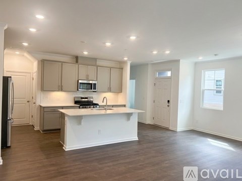 A kitchen with white cabinets and a white island with a sink.