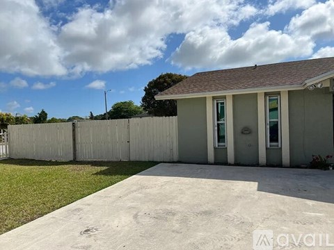 A house with a grey fence and a grey roof.