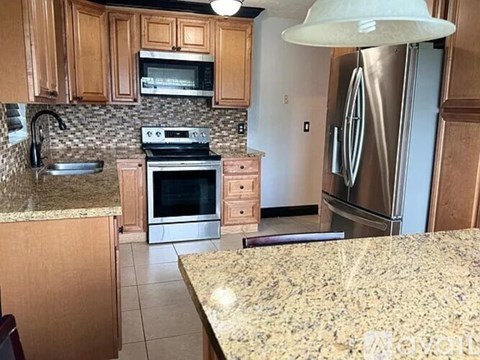 A kitchen with granite countertops and stainless steel appliances.