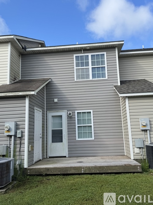 A house with a grey siding and a white door is shown.