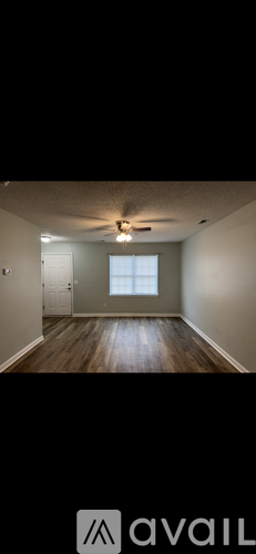 A room with wooden floors and a ceiling fan.