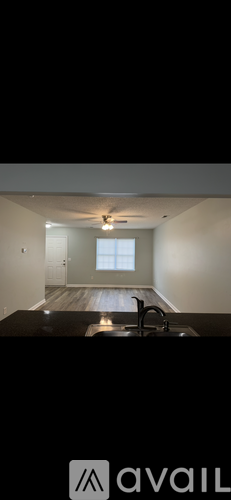 A modern kitchen with a black countertop and a window in the background.