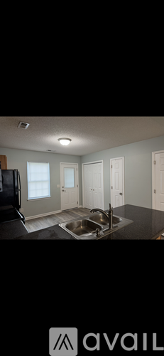 A kitchen with a sink and a refrigerator.
