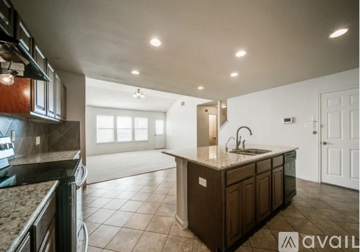 A kitchen with brown cabinets and a granite countertop.