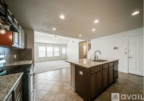 A kitchen with brown cabinets and a granite countertop.