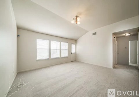 A spacious room with a window and a door.