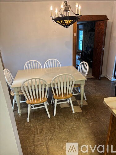 A dining room with a table and chairs and a chandelier.
