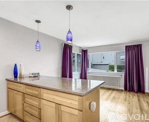 A kitchen with wooden cabinets and a granite countertop.