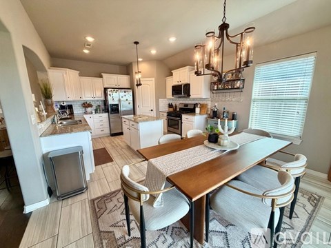 A modern kitchen with a dining table set for two.