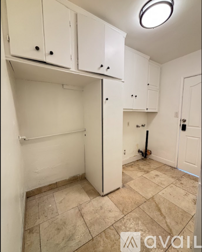 A kitchen area with cabinets and a tile floor.