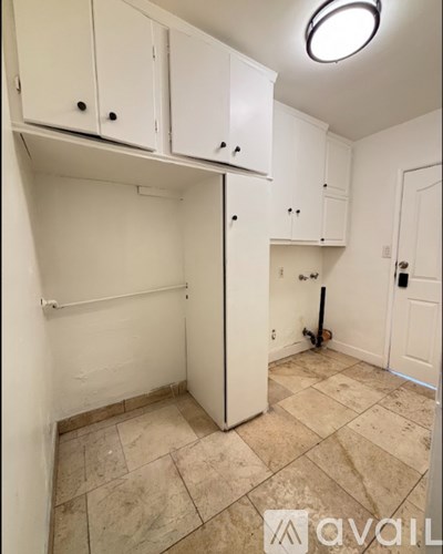A kitchen area with cabinets and a tile floor.