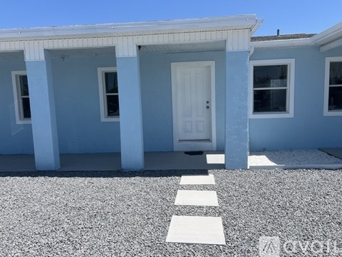 A white door is in the middle of two blue houses.