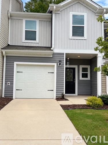 A grey house with a white garage door.