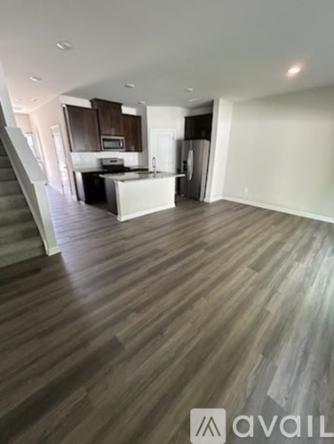 A spacious kitchen with a bar counter and a staircase.