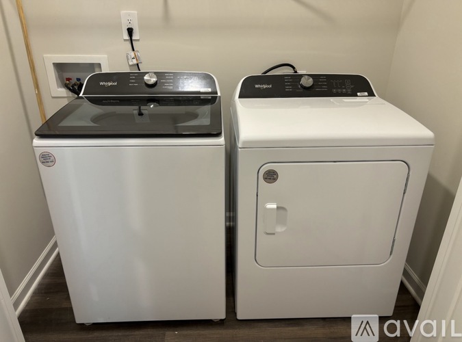 Two white front loading washing machines in a laundry room.