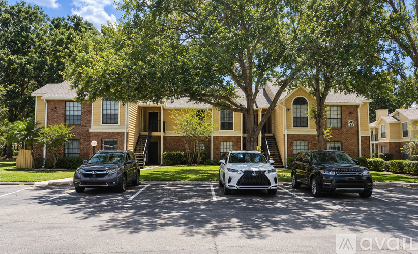 A row of houses with cars parked in front.
