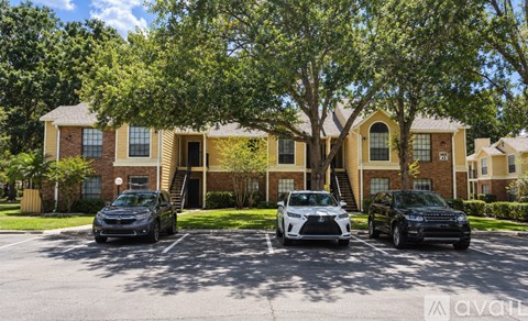 A row of houses with cars parked in front.