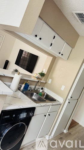 A small kitchen with a washing machine and a sink.