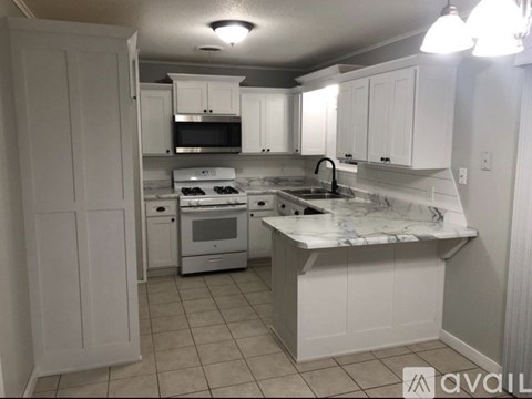 A kitchen with white cabinets and appliances.