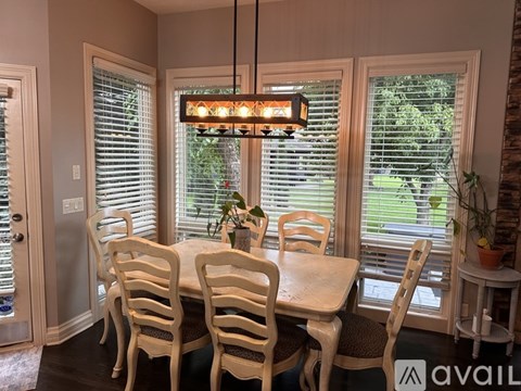 A dining room with a table and chairs.