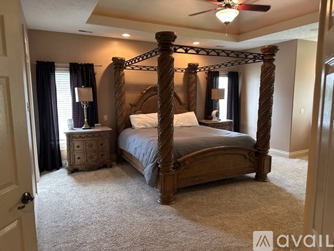 A bedroom with a four poster bed and a carpeted floor.