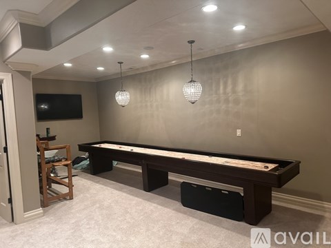 A room with a pool table and a television.